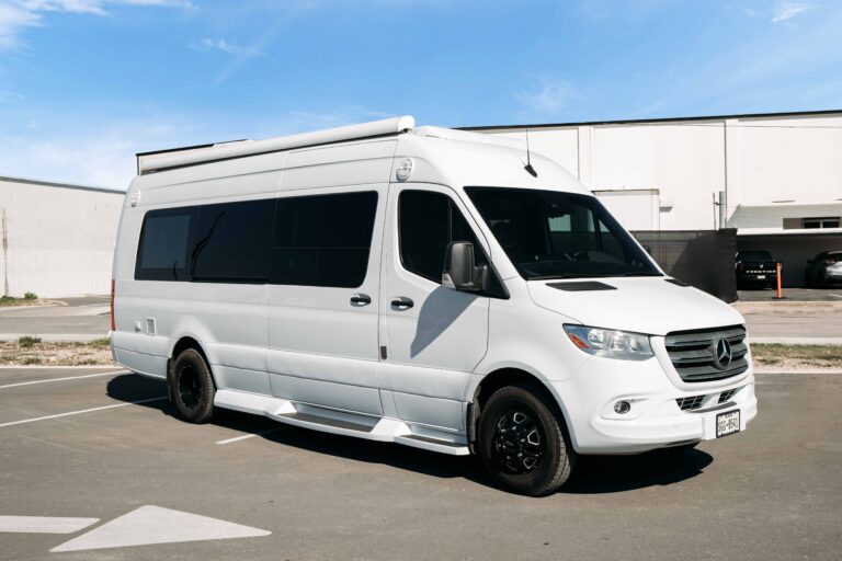 White Mercedes-Benz luxury Sprinter parked outdoors, showcasing clean exterior lines and high-roof design.