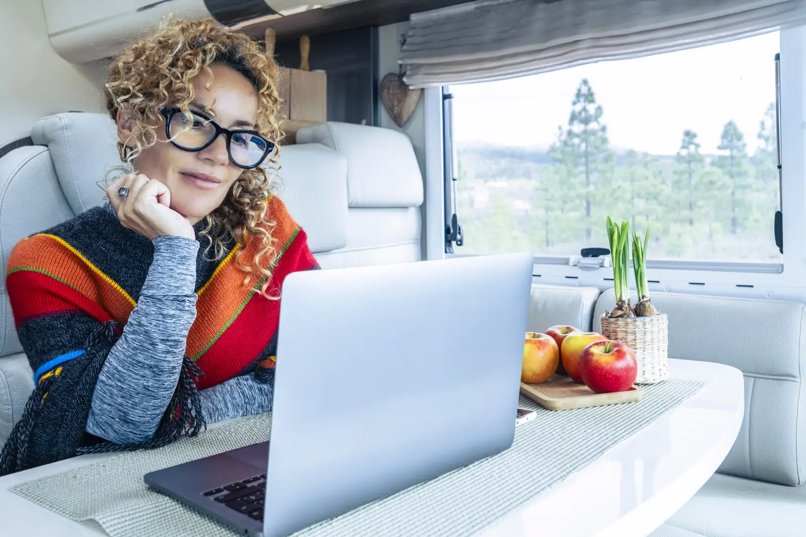 Woman using laptop in van, exploring wifi on the road with satellite mobile office options