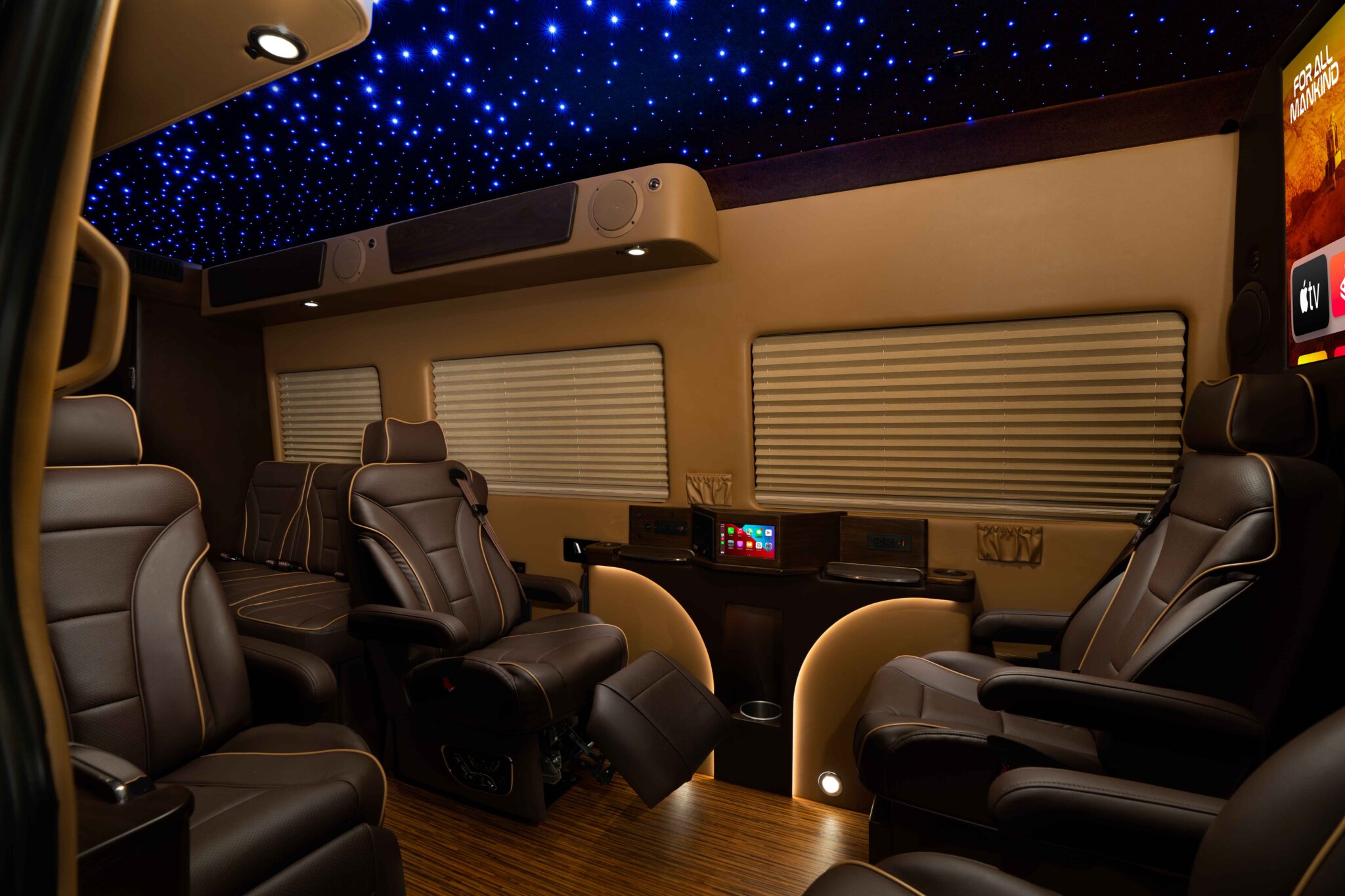 Luxury sprinter cabin with leather seating, starry LED headliner, and a built-in media center.