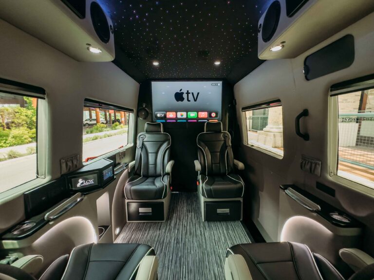Luxury sprinter lounge with starry-sky ceiling, two plush seats, and Apple TV interface on the display.
